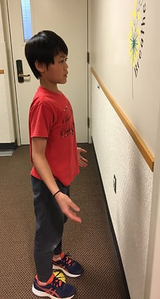 Child facing wall doing an occupational therapy exercise