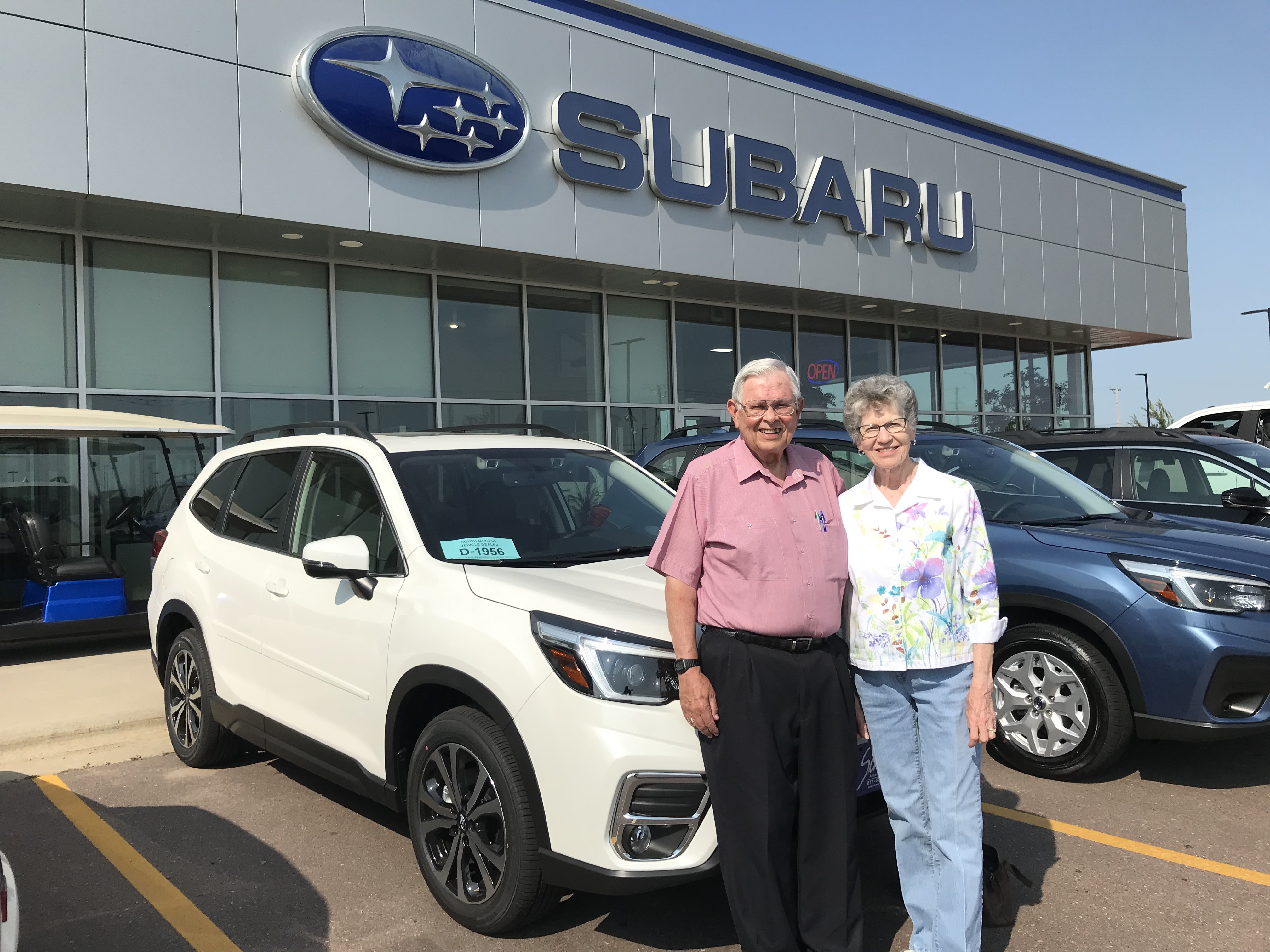 James Berven and wife stand in front of a white Subaru Forester at the Sioux Falls Schulte Subaru dealership